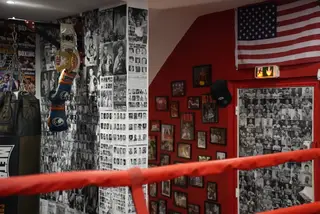 Décor vintage de la salle SBC Chaillot : drapeau américain, ceinture, gants et mur de photos de boxeurs