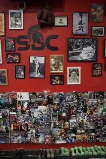 Mur rouge de la salle SBC Chaillot avec le logo SBC et les portraits encadrés de légendes de la boxe, dont Muhammad Ali