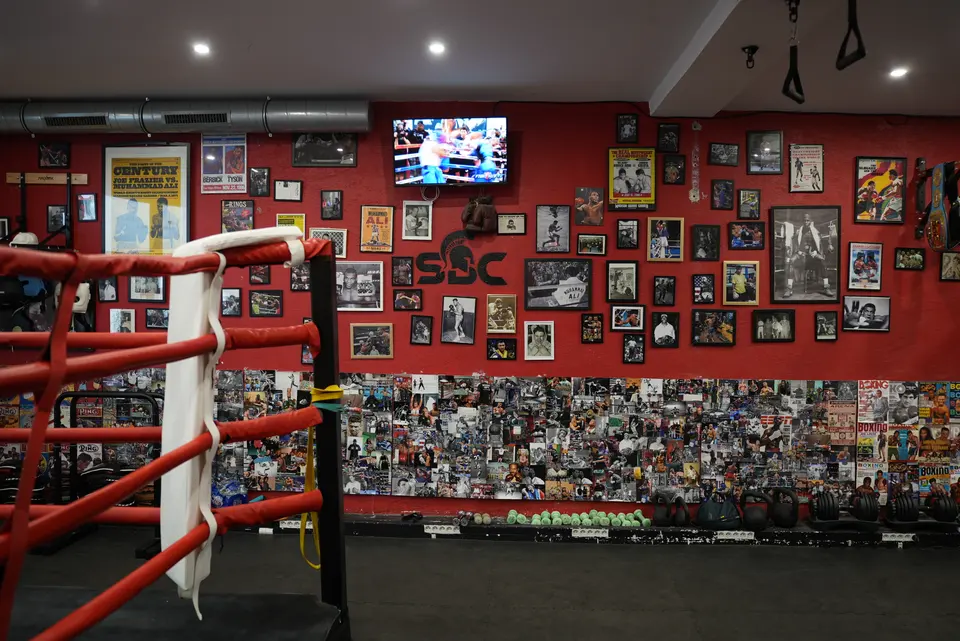 Ring de boxe de la salle SBC Chaillot (Paris 16e), mur rouge au logo Spartan Boxing Club et photos de légendes de la boxe