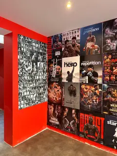 Mur rouge couvert d'affiches et de photos de légendes de la boxe, salle SBC Miollis
