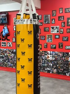 Sac de frappe Mayweather Promotions jaune et noir, salle de boxe SBC Paris 15